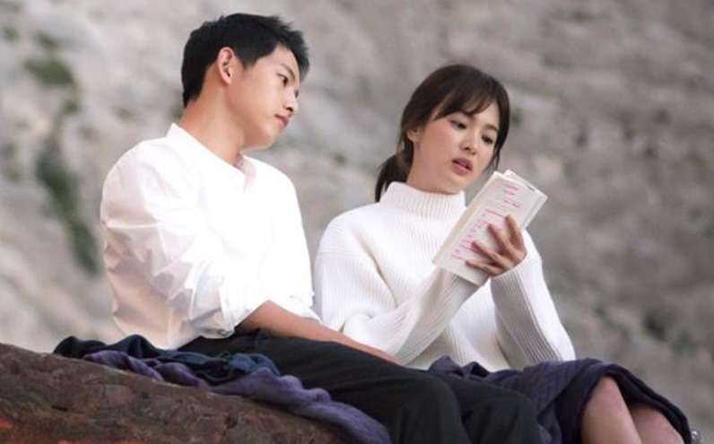 Reading together on hillside.