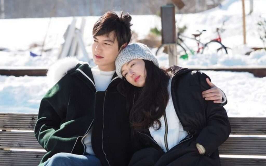 Couple cuddling on snowy bench