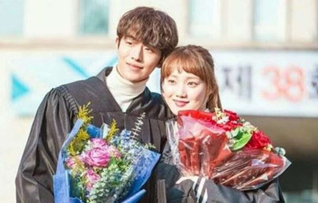 Happy graduates holding flower bouquets