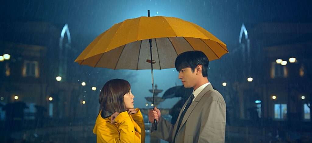 Couple under yellow umbrella, night