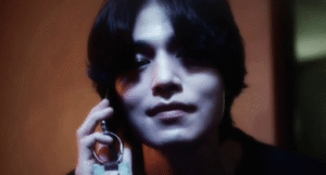 Man smirking while holding phone. 