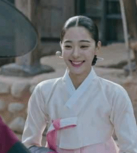 Smiling woman in traditional hanbok.
