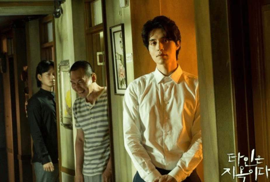 Man in hallway with others. 