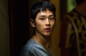 Man standing in dim hallway. 