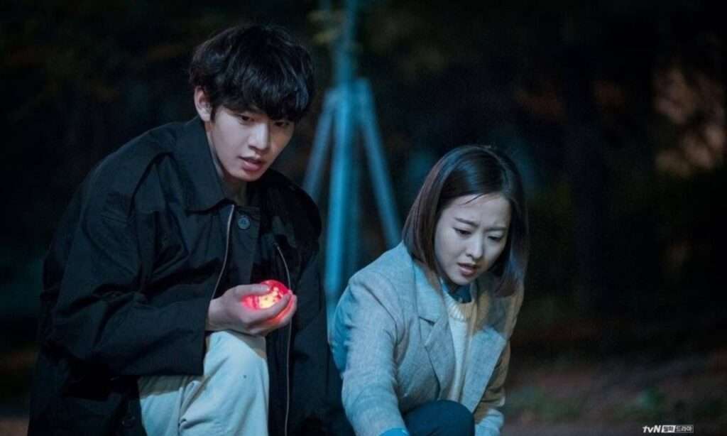 Man and woman discover glowing orb. 