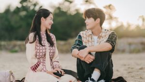 Couple sitting together, smiling warmly.
