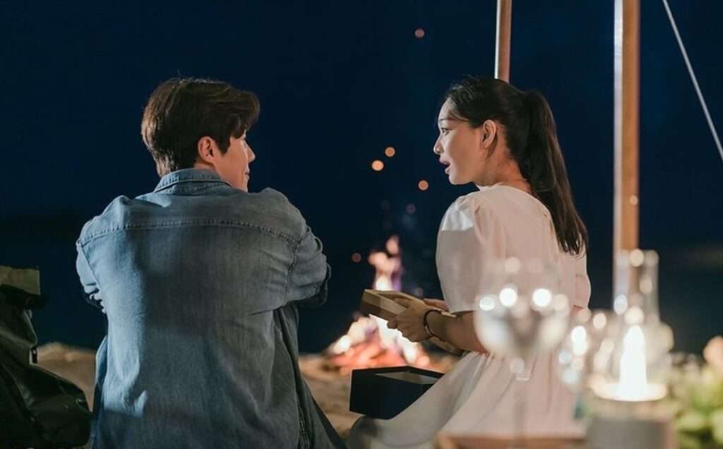 Couple talking near evening fire.