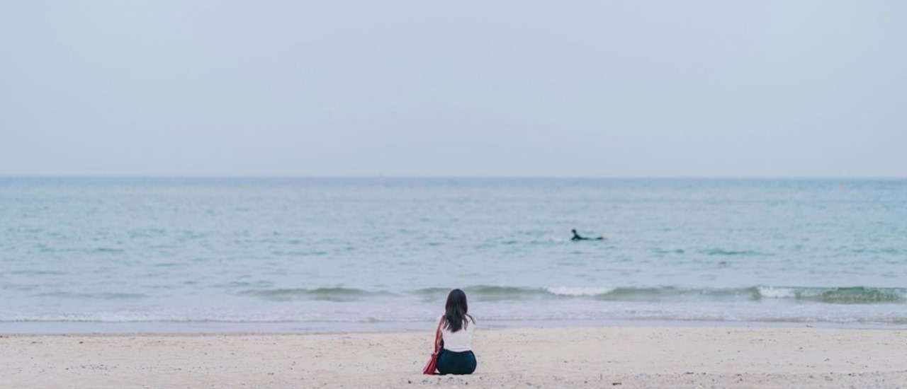 A girl sitting alone on tha beach