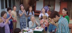 Family celebration with cake outside.
