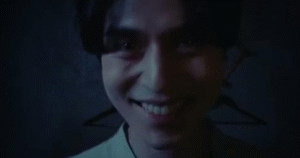 Man smiling in eerie lighting. 