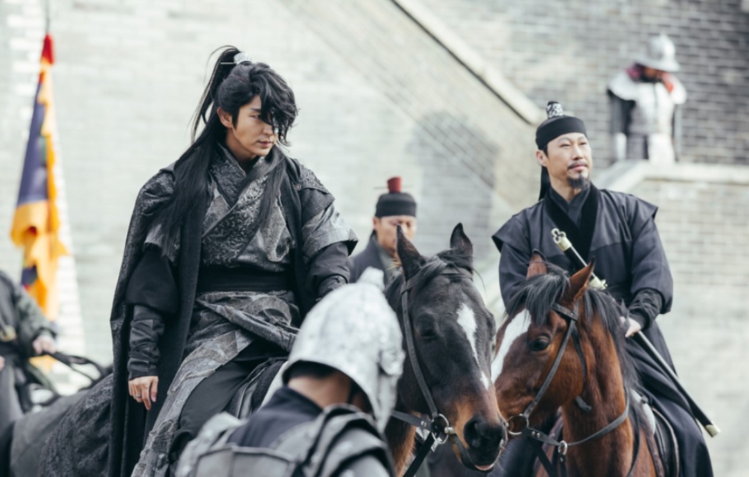 Moon Lovers: Scarlet Heart Ryeo action-packed scene featuring Lee Joon-Gi and a fellow warrior on horseback, dressed in royal battle attire, highlighting the intensity and strategic dynamics of the drama’s royal conflicts