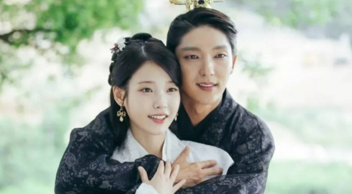 Moon Lovers: Scarlet Heart Ryeo heartwarming moment between IU and Lee Joon-Gi, as Lee Joon-Gi embraces IU from behind in traditional royal attire, capturing their deep love and affection in a serene outdoor setting