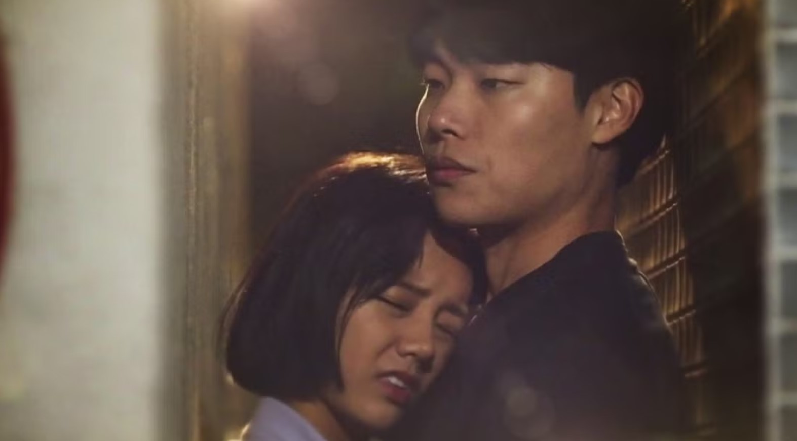 Emotional moment from Reply 1988, where two characters share a heartfelt embrace in a quiet and intimate scene, showcasing deep connection and vulnerability.