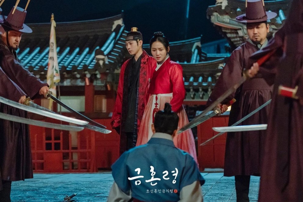 Intense scene from The Forbidden Marriage, where the main characters are surrounded by guards with swords drawn in a dramatic moment, set against a traditional Korean palace backdrop.