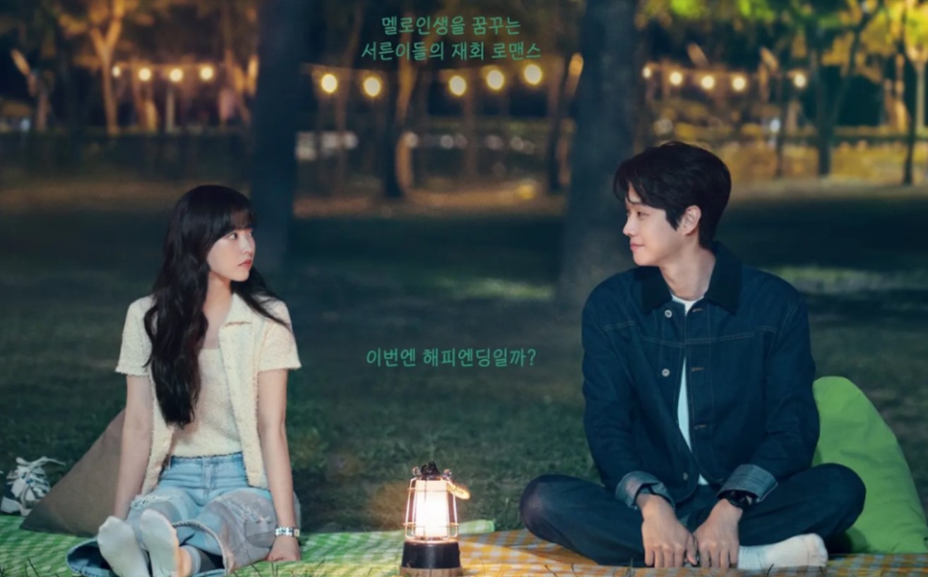 A romantic scene from Melo Movie, showing a couple sitting across from each other on a blanket under the night sky, with a lantern in the center. The two characters share a tender moment in a park setting.