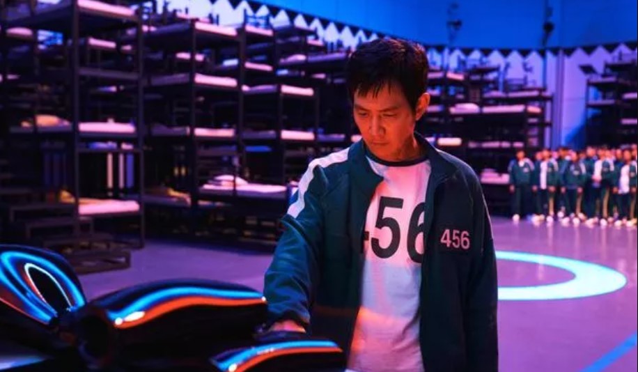 Squid Game Season 2 full review - suspenseful moment of a contestant interacting with a high-tech device, set in the eerie, dimly lit environment of the game.