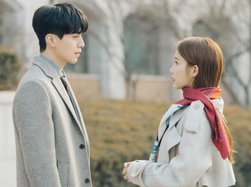 Main characters from the drama Touch Your Heart – the man in a grey coat and tie standing with his side to the woman in a beige coat and scarf, both looking at each other.