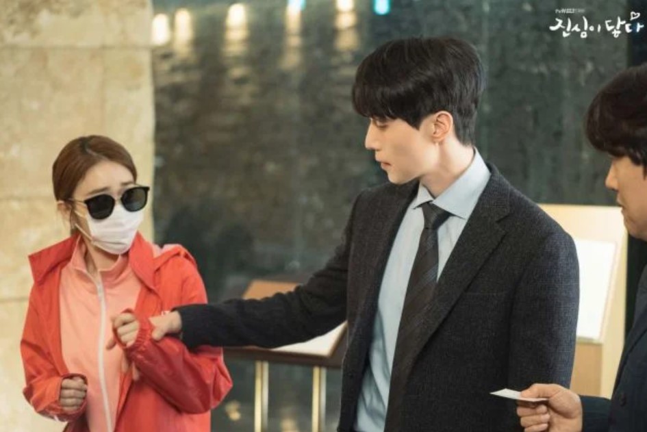 Main characters from the drama Touch Your Heart – the woman in a pink jacket, sunglasses, and a mask, looking at the man in a suit as he holds her hand. Touch Your Heart full review