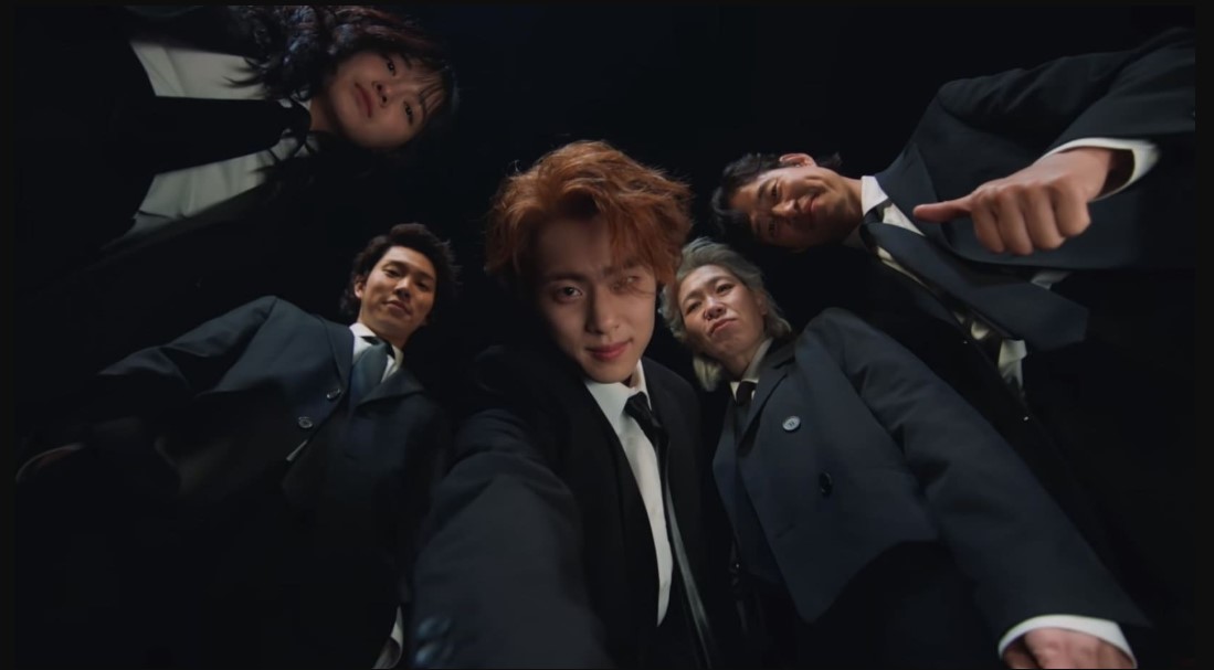  Main characters from "The Uncanny Counter 2," wearing suits and ties, pose together in a professional setting.