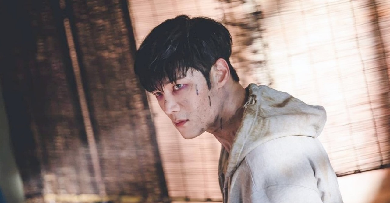 Zombie Detective K-Drama scene showing the male lead in zombie form, with a fierce expression and dirt on his face, wearing a hoodie.