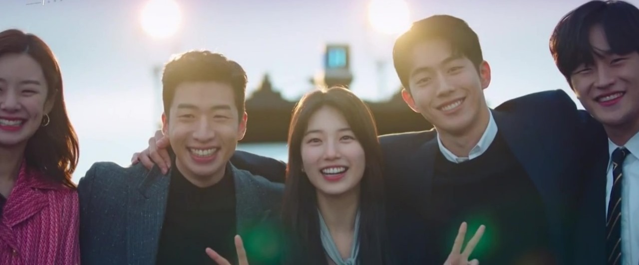 A joyful group photo from *Start-Up*, featuring the main characters smiling and posing together with peace signs, set against a sunny backdrop, capturing their close-knit bond and happy moment.