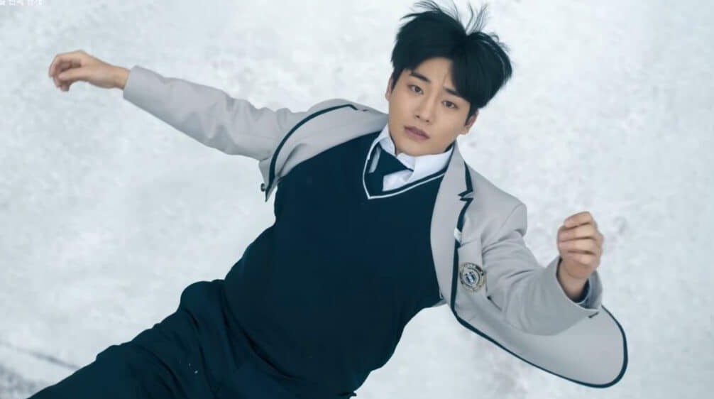 Male character from 'Revenge of Others' lying on the ground, wearing a school uniform with a shocked expression, set against a snowy background.