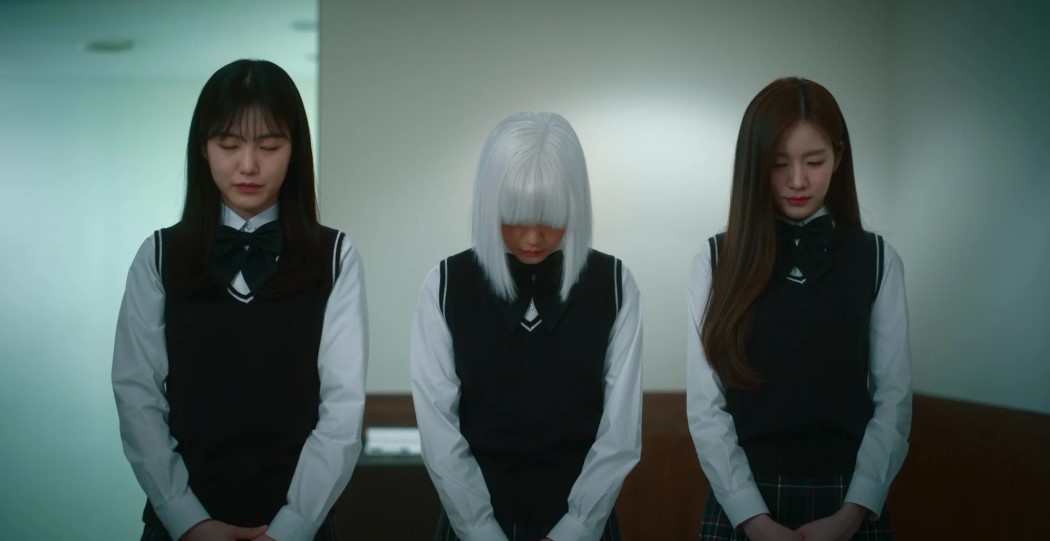 Three female characters from 'Revenge of Others' in school uniforms, bowing with serious expressions, with one character having short white hair, standing in a dimly lit room.