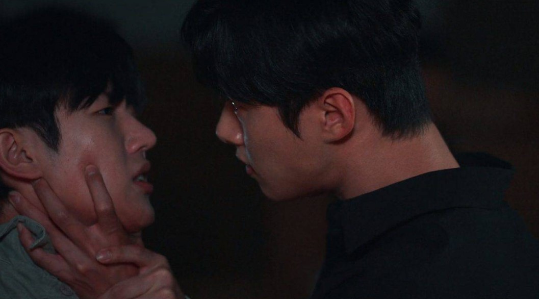 Intense confrontation between two male characters from 'Revenge of Others,' with one character gripping the other's neck in a tense, close-up scene.