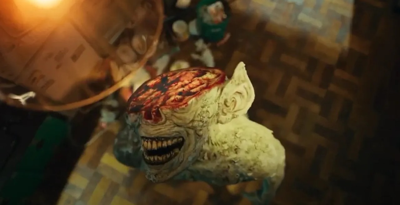 "Close-up of a grotesque monster from Sweet Home, with a twisted, gaping smile and a bloody, exposed brain, creating a terrifying and surreal visual.