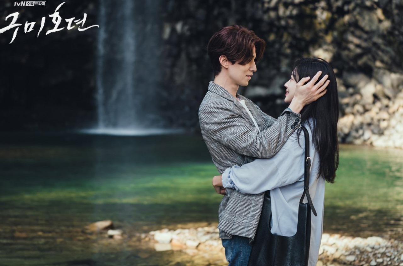 Romantic moment from 'Tale of the Nine-Tailed' showing Lee Dong-wook and Jo Bo-ah embracing by a waterfall, capturing their deep connection and love.