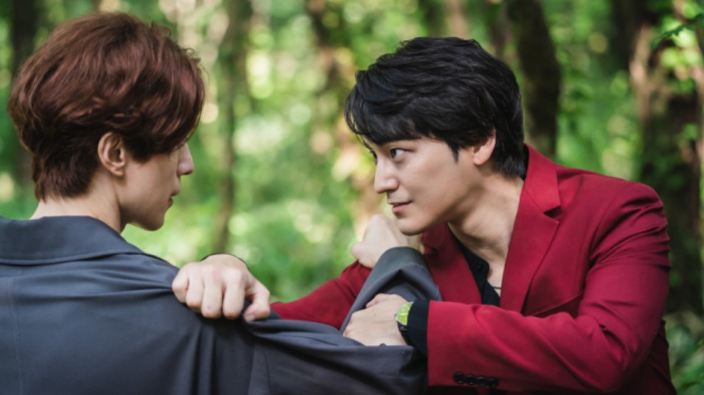 Intense confrontation scene from 'Tale of the Nine-Tailed,' featuring Lee Dong-wook and Kim Bum in a tense face-off in a forest, showcasing their characters' rivalry.