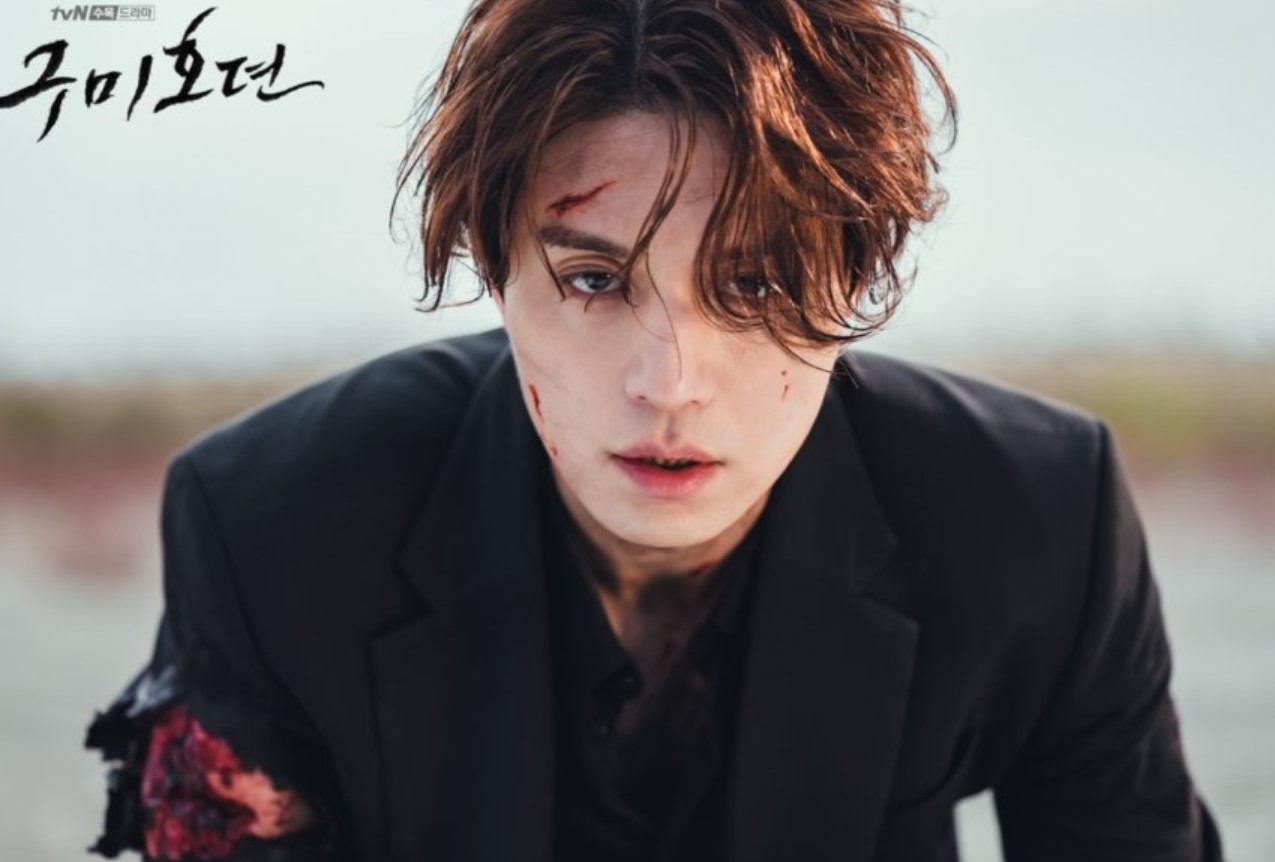 Lee Dong-wook's character from 'Tale of the Nine-Tailed' covered in blood and dirt, showcasing a dramatic moment of intense struggle and emotion.