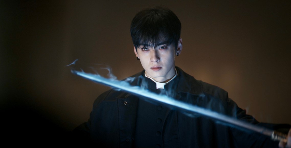 Character from the 'Island' drama series holding a glowing sword, exuding intensity with a fierce expression and a dark, mysterious backdrop.
