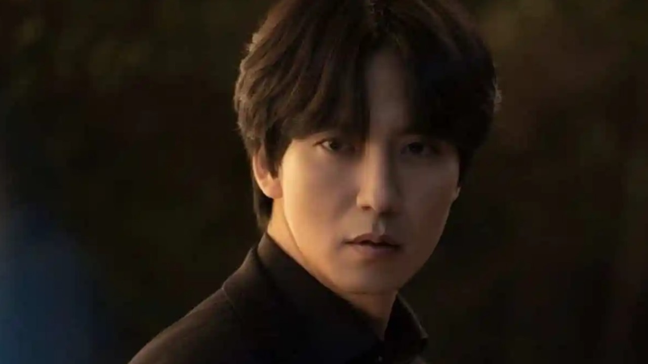 Close-up shot of a character from the drama 'Island,' showcasing a serious expression with a dark background, exuding intensity and mystery.
