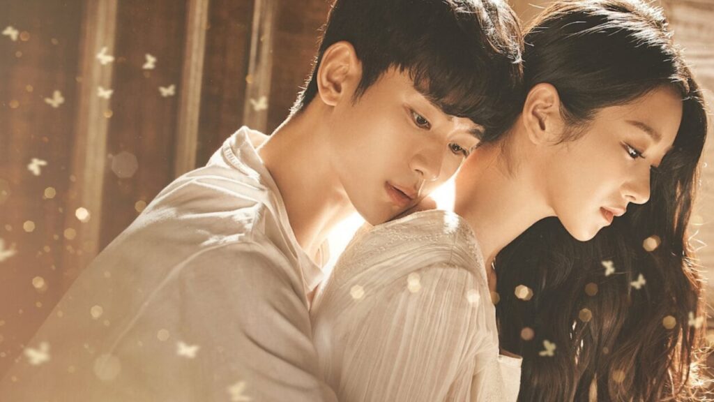 Drama character development in 'It's Okay to Not Be Okay' as the main characters share an emotional moment, capturing their growth and connection in a tender embrace surrounded by soft lighting and butterfly motifs.