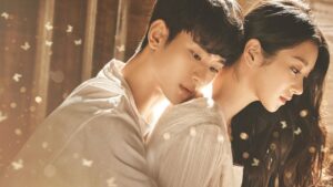 Drama character development in 'It's Okay to Not Be Okay' as the main characters share an emotional moment, capturing their growth and connection in a tender embrace surrounded by soft lighting and butterfly motifs.