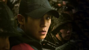 Main character in a tense moment from D.P. Season 2, wearing a black cap and surrounded by soldiers — DP Season 2 Full Review