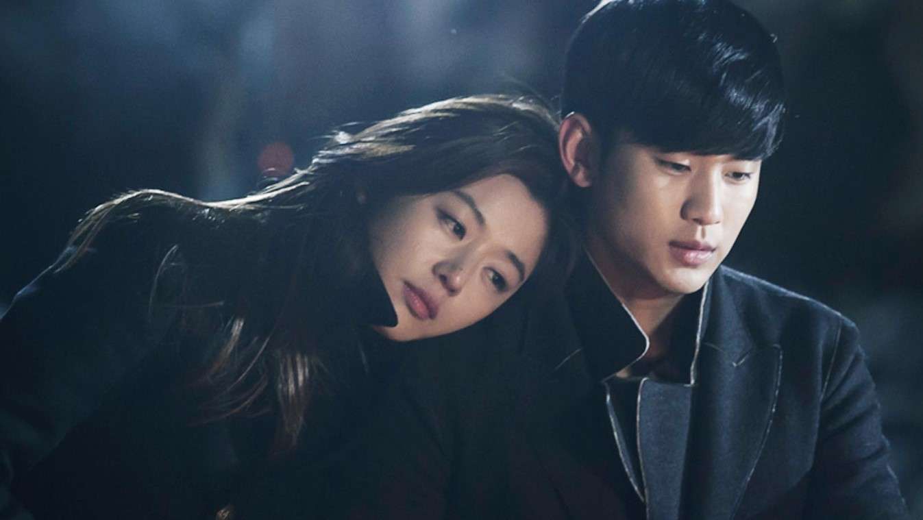 A couple sitting closely together in a dimly lit space, evoking the romantic atmosphere of classic KDrama OSTs.