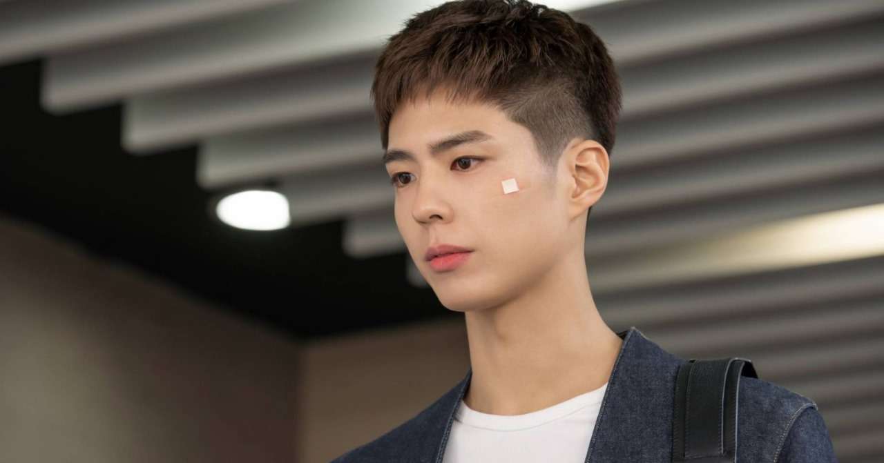 Sa Hye-jun (Park Bo-gum) walking with a bandage on his face in a scene from 'Record of Youth,' showcasing a moment of vulnerability in his character's journey.