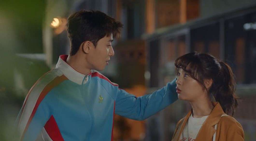 Park Seo-joon and Kim Ji-won in an emotional scene from Fight for My Way, with Park Seo-joon gently touching Kim Ji-won’s shoulder as they share an intimate moment, showcasing their deep connection and growing romance in the drama.