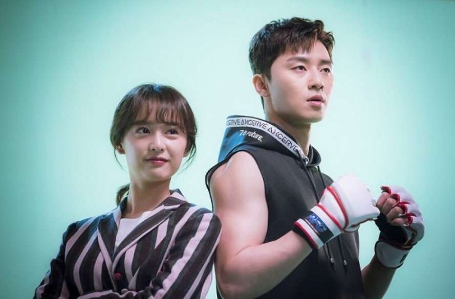 Park Seo-joon and Kim Ji-won in a promotional photo for Fight for My Way, with Park Seo-joon striking a confident pose in boxing gloves and a sleeveless hoodie, while Kim Ji-won smiles playfully beside him, showcasing their dynamic and chemistry in the drama.