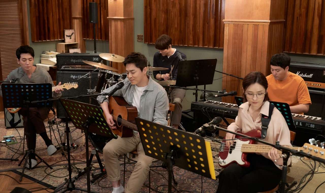 Hospital Playlist+ cast performing music together in a studio, with characters playing various instruments including guitar, bass, and drums.