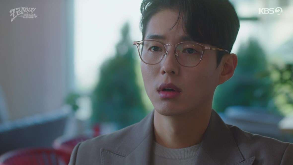 Close-up shot of a male character from 'Crazy Love' looking surprised and concerned, wearing glasses, set in a bright, modern indoor setting.