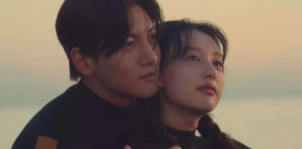 A tender moment between the leads of Love Struck in the City, embracing by the water at sunset, highlighting the K-drama's romantic essence.