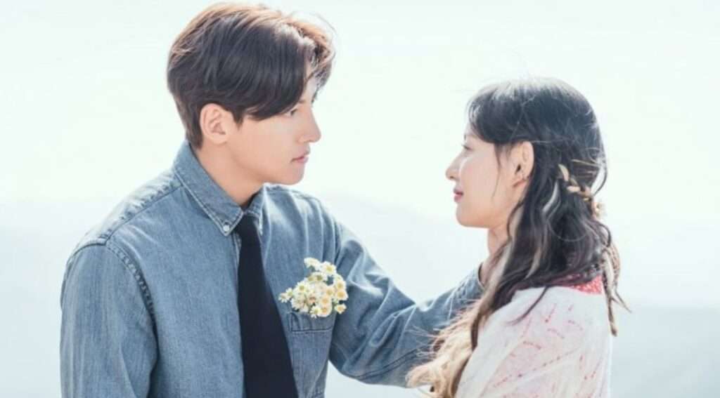 A tender moment from Love Struck in the City with a couple sharing an intimate gaze, the man holding flowers, set against a serene backdrop.