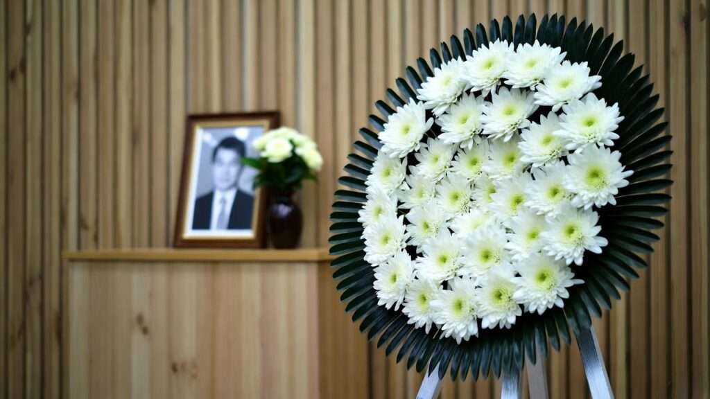 White chrysanthemum wreath in traditional Korean funeral hall setup for respectful mourning etiquette.