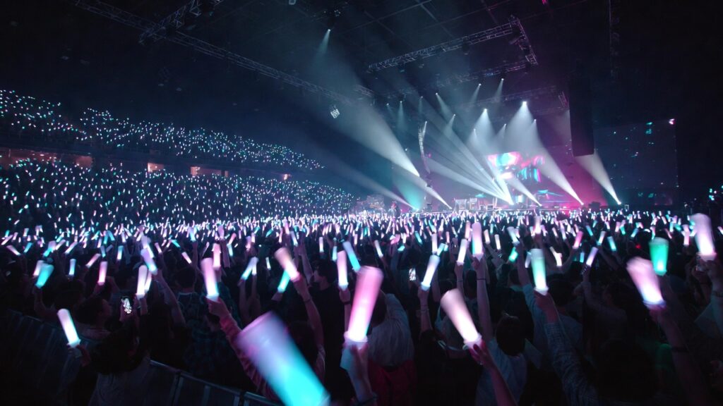 Vibrant Kpop concert crowd with lightsticks representing fandom unity and culture.